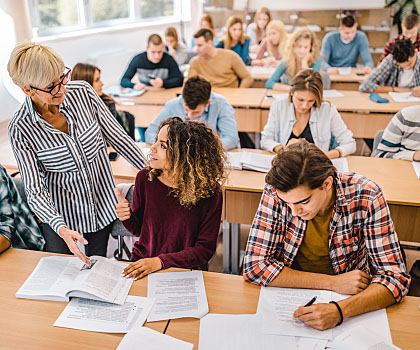 Teacher in classroom assisting a student