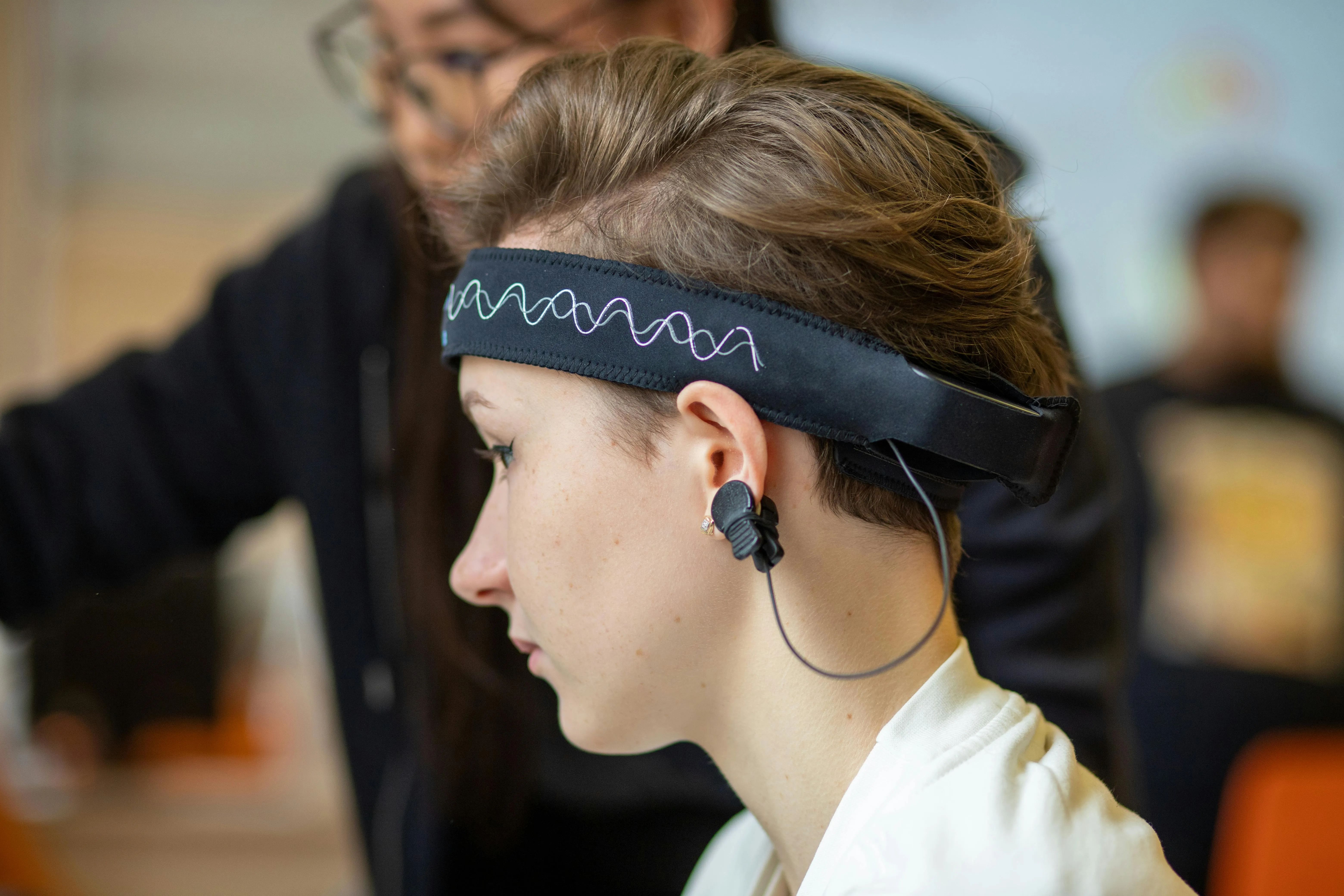 Close-up of a woman wearing an EEG headband during a study