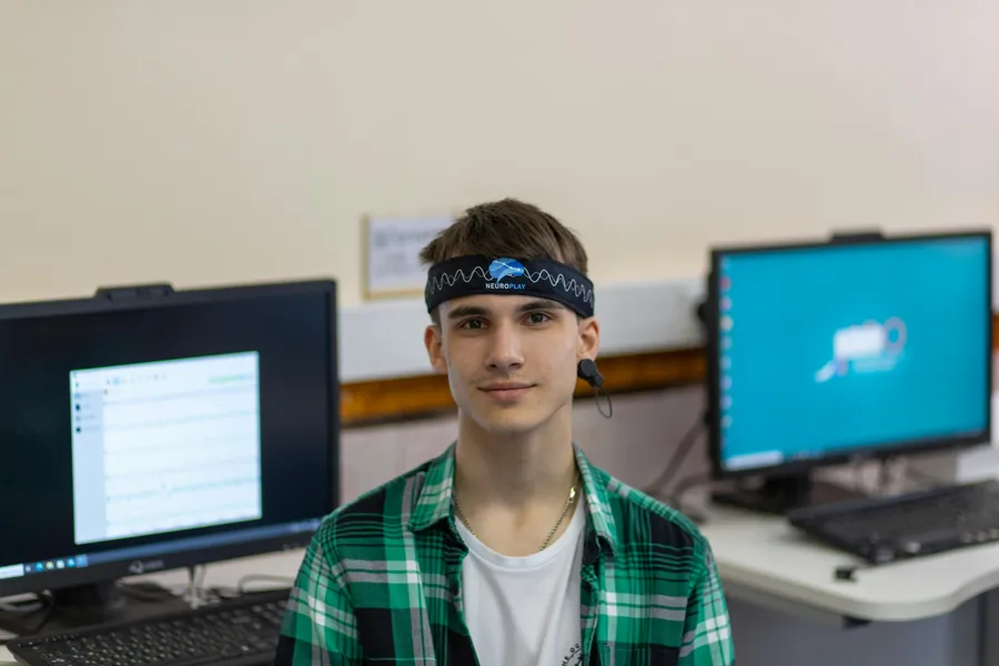 Young participant wearing NeuroPlay EEG headband in a research lab