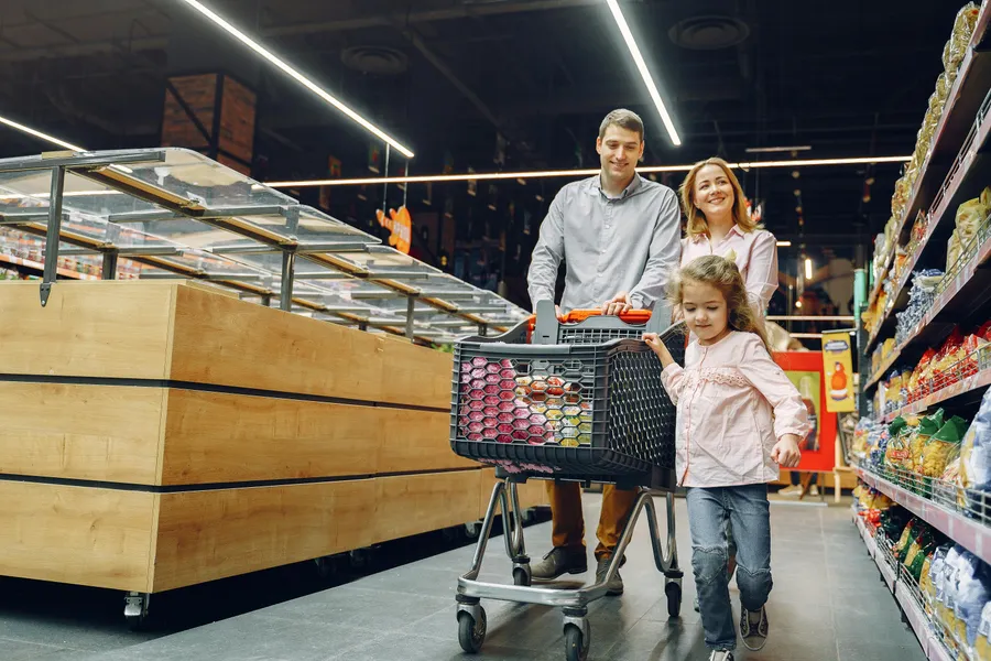 Family with child shopping in a supermarket with a cart