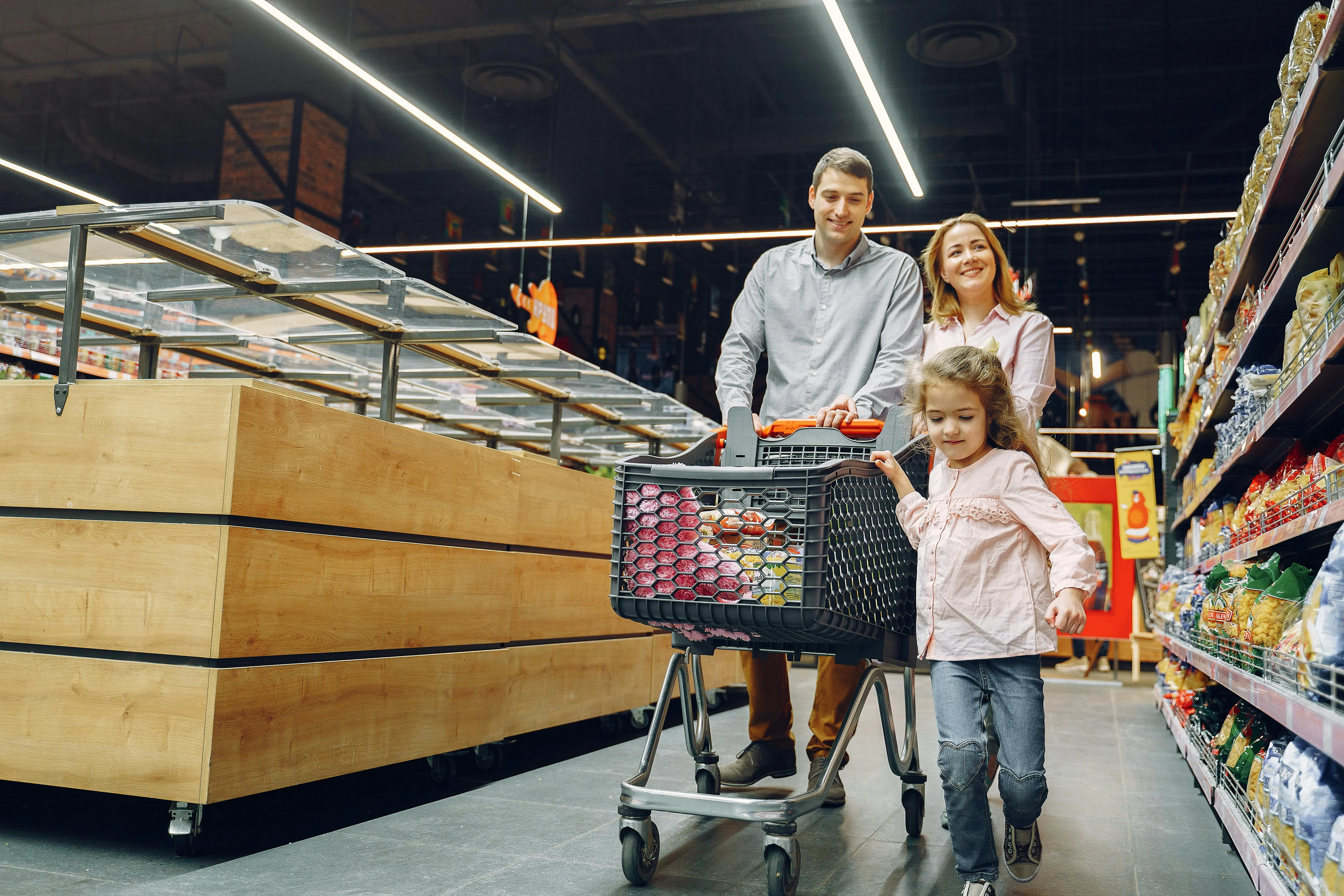 Family with child shopping in a supermarket with a cart