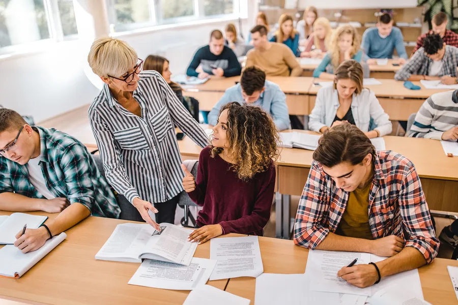 Teacher in classroom assisting a student